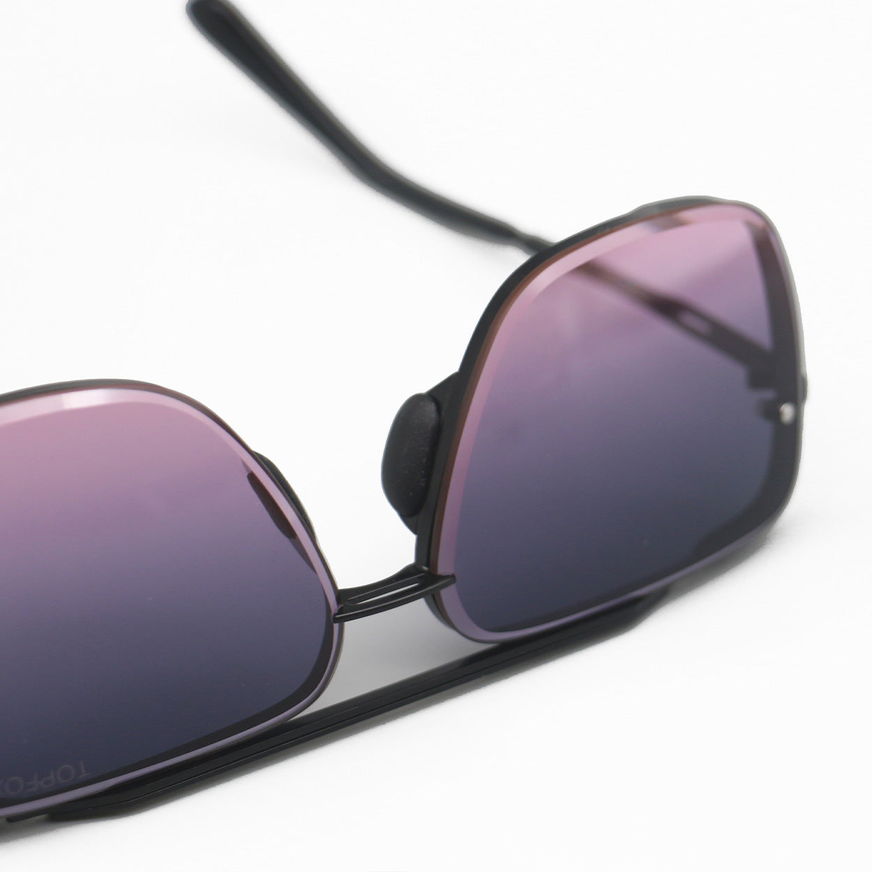 Clese up of Bella Sunglasses with no nose pad. Square aviators with faded purple to pink lenses.