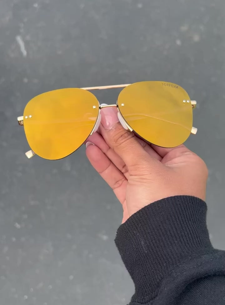Video of hand-holding classic aviators with no nosepad and  mirrored gold  lenses with metal detailing. Then Model wearing the sunglasses. 
