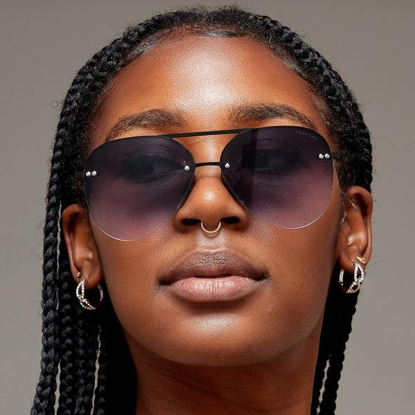 model of color wearing classic Aviators with faded black lenses and metal detailing 