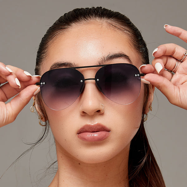Model wearing classic Aviators with faded black lenses and metal detailing