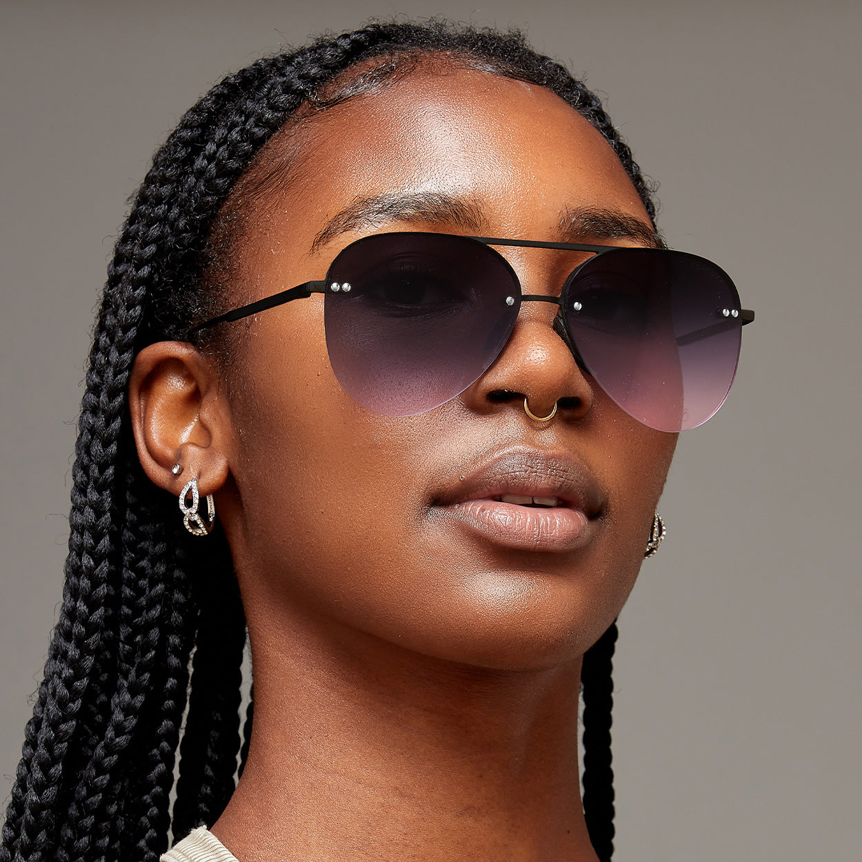 Model of color wearing classic aviators with no nosepad and faded purple pink lenses with metal detailing
