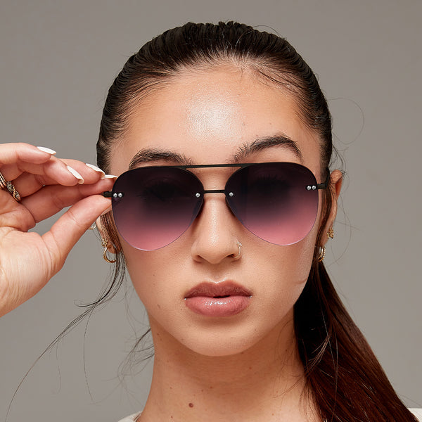 Model wearing classic aviators with no nosepad and faded purple pink lenses with metal detailing