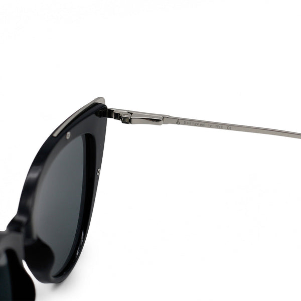 Close up view of white background picture of oversize black glossy cateye sunglasses with metal detailing