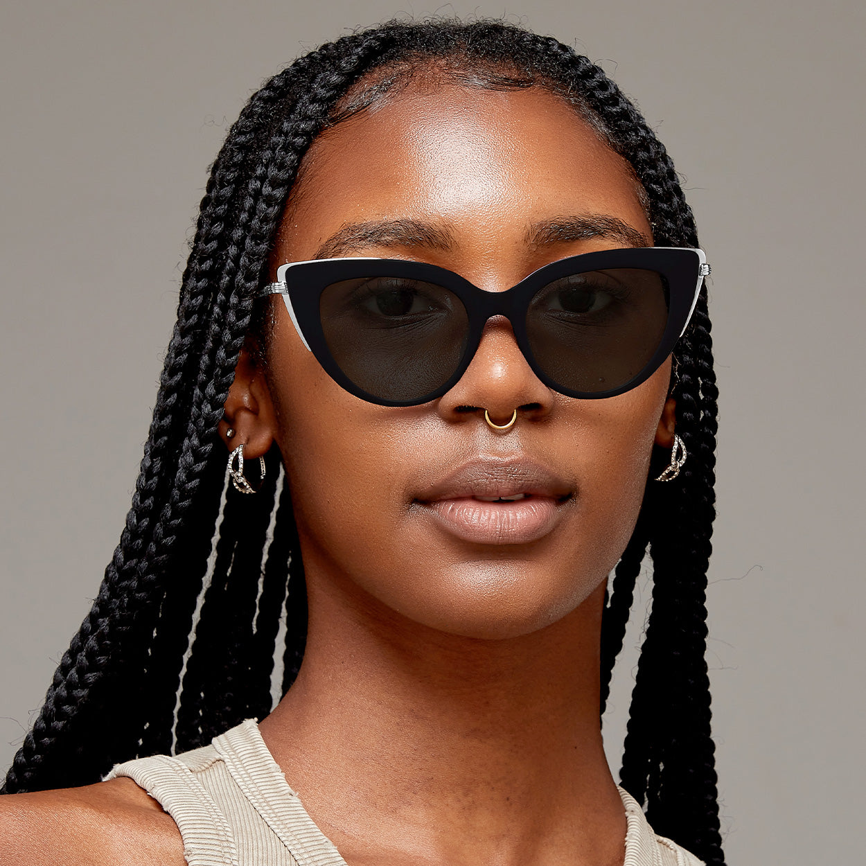 Front view Model of color wearing oversize glossy black cateye sunglasses with silver metal detailing
