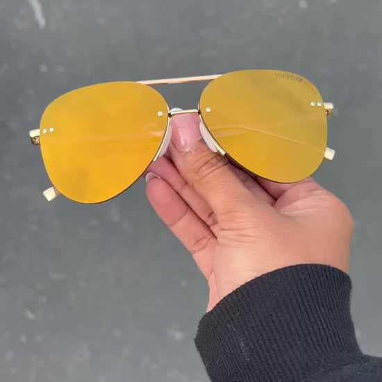Video of hand-holding classic aviators with no nosepad and  mirrored gold  lenses with metal detailing. Then Model wearing the sunglasses. 